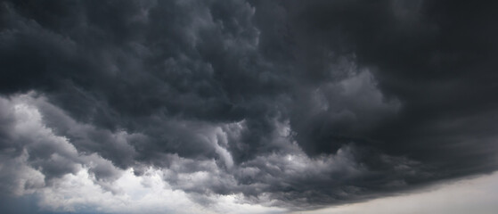 Dark storm clouds gathering in the sky, symbolizing danger, power, and dramatic weather before...