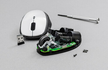 Disassembled Wireless Computer Mouse with Tools and Components