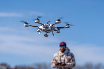 Aerial drone on blur background with blurred drone operator.