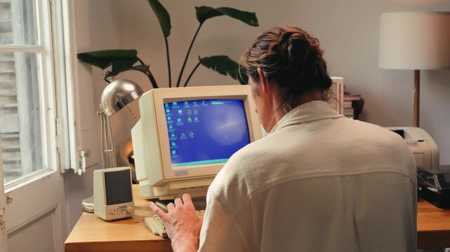 Man working and gaming on retro computer PC, IT engineer with vintage computer at home, using old fashion technology, close up of retro setup. 