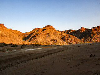 Barren Mountains forming the edge of the Fish River Canyon, Namibia, in the golden light of the setting sun.