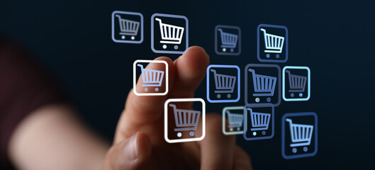 Fototapeta premium Hand touching shopping cart icons, symbolizing online shopping, e-commerce, and digital retail. Concept of accessibility, buying online. Great f