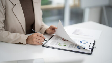 Real estate sales professional reviewing market analysis reports strategic planning business...