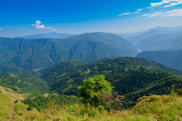 Fototapeta premium View of Himalayan mountain, blue sky and forest from Tarey Bhir point, tourist spot, Sikkim, India. 'Bhir' means cliff in the local language,about 10,000 feet long path, breathtaking view at the edge.