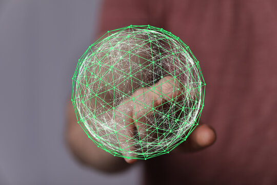 Abstract image of a hand interacting with a glowing green network sphere. Symbolizing technology, connection, and the digital world.