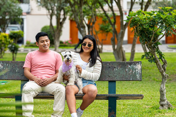 Young latino couple enjoying park time with their beloved pet