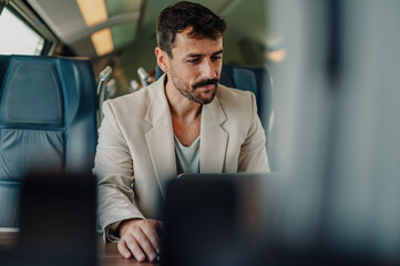 Man working on laptop during train commute