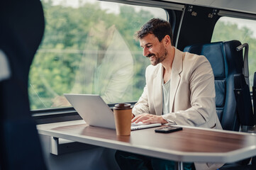 Millennial man working on laptop traveling by train © Zamrznuti tonovi