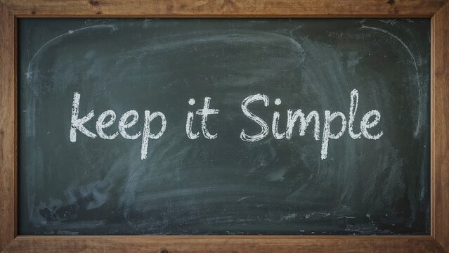 Keep It Simple written in chalk on a used blackboard, a well known saying for strategy, project management and planning.