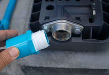 Plumber's Hand Wrapping White PTFE Thread Seal Tape Around a Male Pipe Fitting