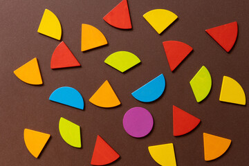 fractions geometric shapes arranged in a creative pattern on a brown background