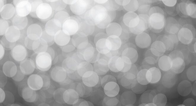 Abstract background of blurred white bokeh lights, creating a soft, dreamy, and magical effect with a shallow depth of field