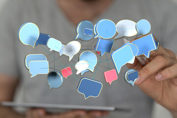 A hand interacting with connected speech bubbles representing networking, social media and...