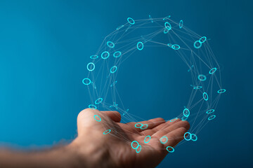 A close-up shot of a hand holding a glowing digital network against a vibrant blue background,...