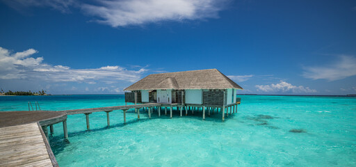 Top Luxury Maldives Water Villas over the Gorgeous Turquoise Ocean Lagoon. Best Sunny Tropical Nature Scene creates the Perfect Summer Holiday Tourism Background Exclusive Popular Vacation Destination