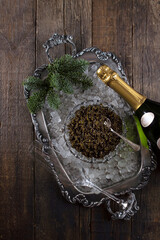 Black caviar and champagne. Caviar on a crystal plate. Ice on a tray. Black caviar on ice. Natural omega. Flat lay. Top view. Copy space.