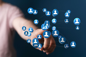 Concept of social network and global connections depicted with hand interacting with people icons. Represents community, communication, and digi