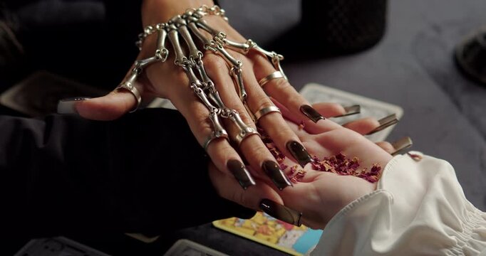 Witch holding client palm during mystical fortune ritual