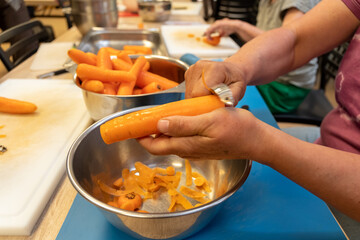 Frau schält eine Schüssel voller Karotten