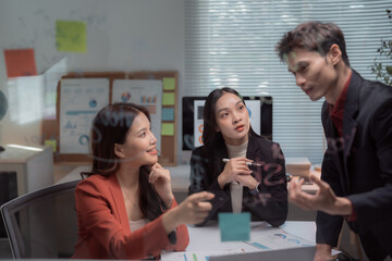 Asian business team members actively collaborating, discussing, and brainstorming ideas while working together on a project in a modern office meeting, reflecting partnership and teamwork