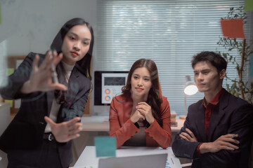 Asian business professionals collaborating in a modern office, sharing ideas and analyzing data on a transparent screen, fostering teamwork and strategic planning