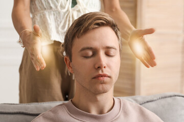 Reiki master healing patient's aura during therapy indoors, closeup