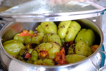 Close-up of peppers stuffed with meat cooked in a pot. Sliced ​​tomatoes and sumac sprinkled on top. Traditional Turkish home cooking. Stew. Stuffed peppers are filled with ground meat.
