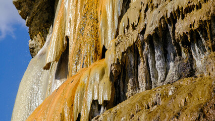 travertine waterfall close-up image, with mineral waters, the waterfall turned into chalky and colorful travertines.