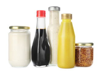 Bottles and jars with different tasty sauces isolated on white