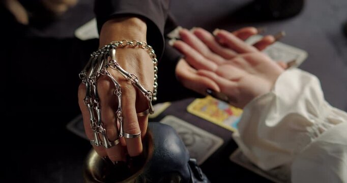 Witch reading client palm in mystical fortune ritual