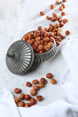 Hazelnuts in a tin vase. A natural product. A light background. Vertical photo.