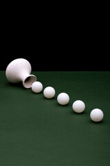 Still Life with white vase and white balloons on a green table
