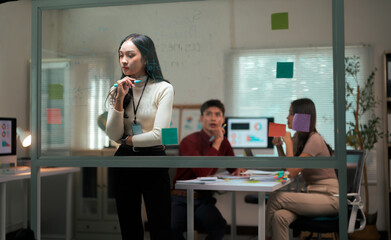 Fototapeta premium Woman brainstorming business strategy ideas on glass board in office