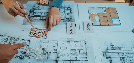 Hands of designers actively engaging in a collaborative session to select color swatches and...