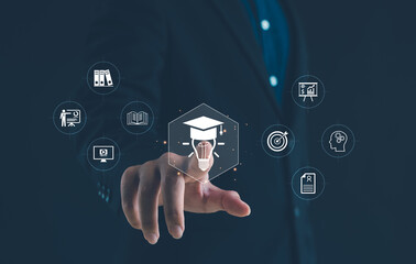 Businessman touching virtual icon of education, innovation, and learning with graduation cap and light bulb, symbolizing knowledge development, e-learning, and modern digital education concept.