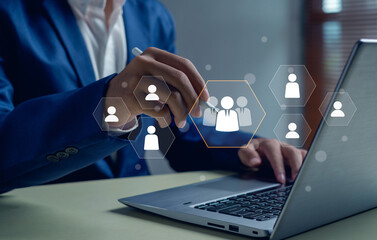 business professional using a laptop and stylus to select a virtual team icon. Concept of digital human resource management, recruitment, leadership, teamwork, and business networking.