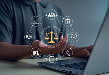 Business person using digital justice scale and law icons above laptop symbolizing legal services, corporate compliance, fairness, protection, and professional consulting in modern technology.