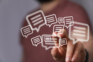 Hand reaching towards floating message bubbles representing communication, social media, and digital interaction. Illustrates concepts of sharin