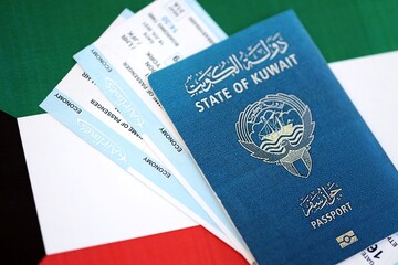 Kuwaiti passport and boarding pass tickets on flag close up. The concept of travel and vacation