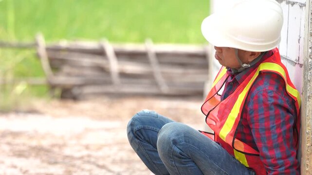 A worker in safety gear stands against a cinderblock wall, showcasing construction readiness and attention to safety protocols.