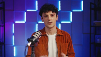 Portrait of male video vlogger recording true crime podcast in radio studio