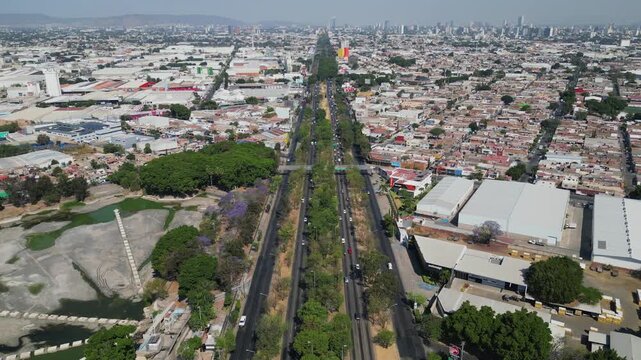 Forward aerial view advancing over Lazaro Cardenas Avenue close to El Dean Park with traffic and trees