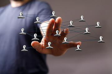 Hand reaching towards network of connected people, symbolizing communication, teamwork, and digital...