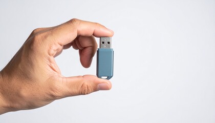 A hand delicately holding a USB flash drive, showcasing a sleek, modern design and its compact size. It suggests ease of portability and data storage