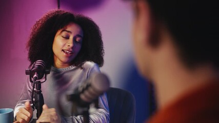 Young black female guest talking with male host in radio studio, interview