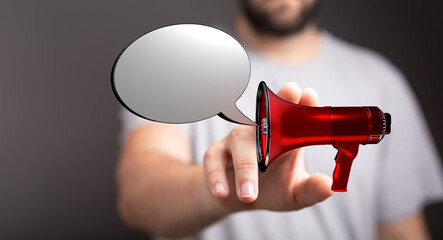 Close up of a man holding a red megaphone with a speech bubble. Concept of announcement,...