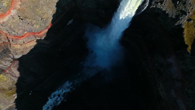 rone flying above Hengifoss waterfall in East Iceland. The camera reveals powerful flow cutting through steep basalt cliffs.