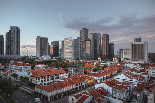 View of a vibrant cityscape where modern skyscrapers pierce the sky behind traditional red-roofed buildings, creating a striking contrast, Singapore, Singapore.
