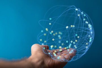 Abstract image showing a hand holding a glowing sphere of connected nodes, symbolizing global...