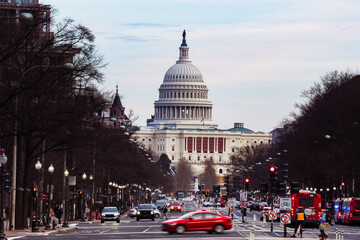 View of the United States Capitol Building stands majestically at the end of a busy street bustling with cars and buses, Washington, District of Columbia, United States.
